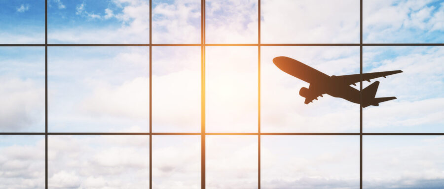 Bildet viser et passasjerfly ved takeoff fra vindu på flyplass